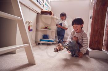 Asian Children Having Fun Playing With Toys In Bedroom Together