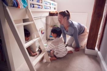 Asian Mother With Children Having Fun Playing With Toys In Bedroom Together