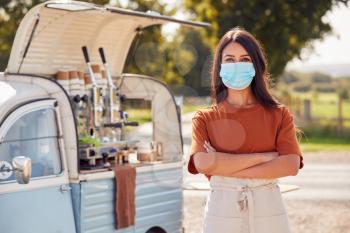 Portrait Of Woman Wearing Face Mask Running Independent Mobile Coffee Shop Standing Next To Van