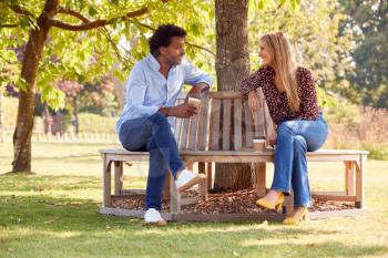 Couple Having Socially Distanced Meeting In Outdoor Park During Health Pandemic