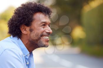 Profile Head And Shoulders Portrait Of Smiling Mature Man Outdoors