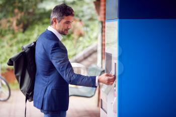 Businessman Commuting Making Contactless Payment For Train Ticket At Station Machine With Card
