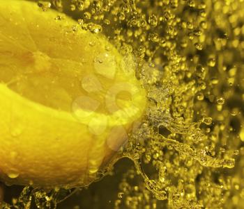 Water splashing onto a lemon