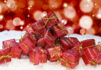 A stack of Christmas gifts in snow on a bokeh lights and stars background