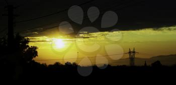 Sunrise background with power pylon and cables silhouettes