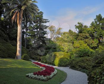  The flowerbeds, green grassy lawn and comfortable path in an exotic park. Lake Como, Villa Carlotta