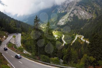 Cars on a steep mountain road turn in the Italian Alps
