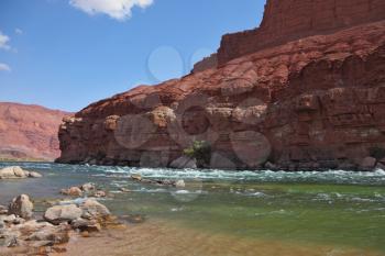 The rapid course of the Colorado River in the red rocks of the desert