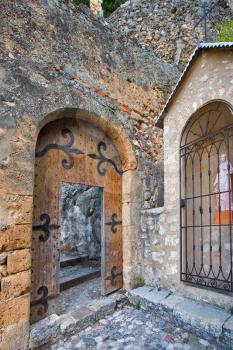 Ancient door, steps leaders in church, and the madonna