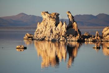 Magic sunset on Mono lake . Ancient lake in a crater of an extinct volcano. Tufa stalactites are reflected in smooth water of lake