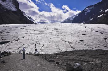Huge majestic glacier in mountains of Northern Canada. The woman-photographer photographes