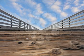 Wooden pier with a handrail. Pacific coast of California, the USA. Solar serene autumn day, the blue sky and easy clouds
