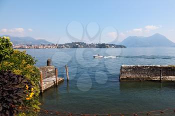 Park on the waterfront of the island of Isola Bella. Fishing boat on lake