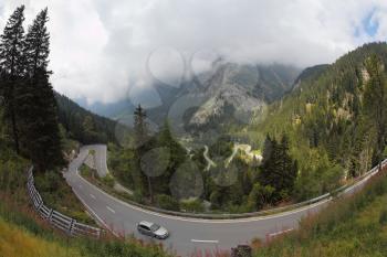Cars on a steep bend in the road
 in the Italian Alps
