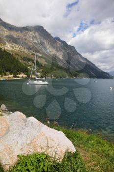 Beautiful mountain Swiss lake. Magnificent sailing yachts are reflected in  cold water