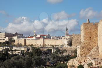 A lovely sunny day in Jerusalem. The walls and towers against the sky and clouds
