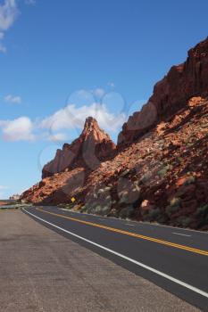 The magnificent American road passes between rocks of red sandstone