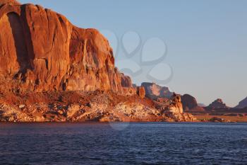 Magnificent red sandstone cliffs on the shores of Lake Powell. Arizona, United States, sunset