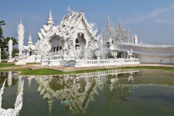Fantastic beauty the White palace in South East Asia. The graceful facade is reflected in a pond with live small fishes
