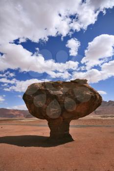 Well-known huge mushroom from the red sandstone, shining clouds and midday shades. The American desert
