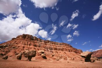 American red rock desert. The famous giant mushroom of red sandstone, glowing clouds, midday shadows