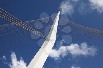 The new up-to-date white bridge in Jerusalem. Strings of a suspension bracket of the bridge and a snow-white support against the dark blue sky
