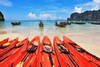 Red modern boats - canoes and boats antique Longtail on a beach in Thailand
