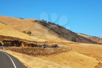 Picturesque hills of California. The car on highway