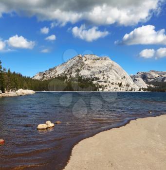 Flat shore of picturesque shallow lake at Tioga Pass in Yosemite Park