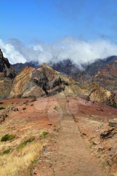 The highest peak of Madeira Island - Pico Ruyvu. A narrow paved path above the cliffs of stone