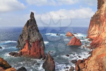 Scenic windy sunset. The eastern tip of the island of Madeira. Red and gray great rock