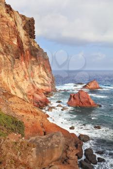 Scenic windy sunset. Eastern end of the oceanic island of Madeira. Red and gray great rock