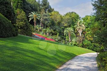  The flowerbeds, green grassy lawn and comfortable path in an exotic park. Lake Como, Villa Carlotta
