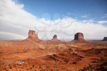 Red Desert. Monument Valley - Navajo Reservation during the summer thunderstorms. The magnificent rainbow over the famous red sandstone Mittens