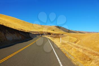 American roads. The magnificent American road passes between autumn hills of California