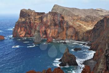 Red rocks and blue sea. Eastern end of Madeira Island at sunset. Deep Bay with picturesque islands - rocks