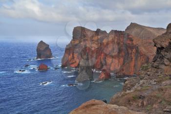 Eastern end of Madeira Island at sunset. Deep Bay with picturesque islands - rocks. Red rocks and blue sea