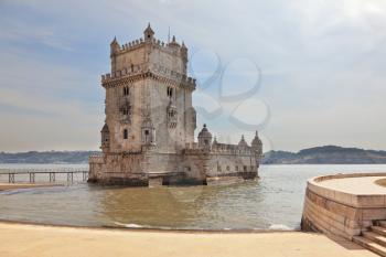 The famous Tower of Belem in the water of the river Tagus. White marble tower is decorated with turrets and battlements in the Moorish style