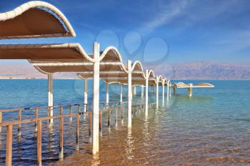 Magnificent beach on the bank of the Dead Sea. Descent in water is issued by a picturesque canopy and a handrail