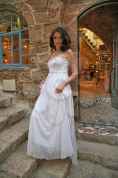 The beautiful bride in a white dress on a background of an ancient workshop of the artist
