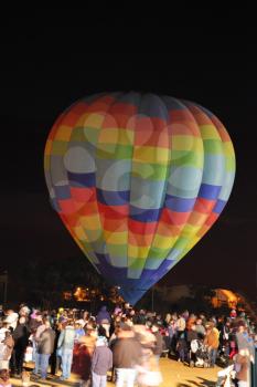 Huge multi-colored balloon in the night sky. Holiday admiring balloons