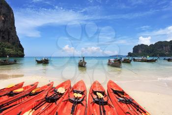 Red modern boats- canoes and boats classic Longtail awaiting tourists. Thailand, the southern islands