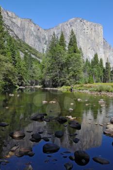 Shallow channel Merced River, covered with stones, in the famous Yosemite Park