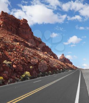 The magnificent marked American road passes between rocks of red sandstone