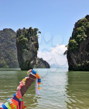  Island-vase in shallow lagoon of Thailand. The magnificent island of James Bond. The native boat of Longtail ornated by multi-colored silk scarfs