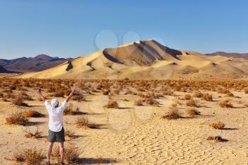 The enthusiastic tourist welcomes sunrise. Magnificent greater sandy dune Eureka in Dead Walley national Park on sunrise