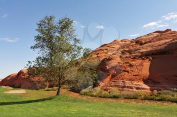 Green lawn and hill from red sandstone. Vicinities of the city of Page in the USA
