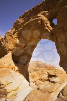 Natural erosive arch in hills from red sandstone in desert