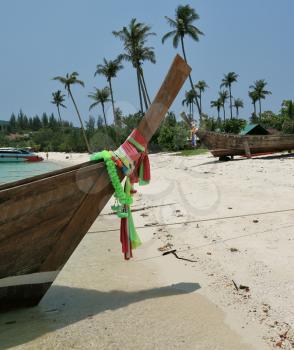 Boat Longtail decorated with silk tapes expects tourists. Island Phi-Phi, Thailand
