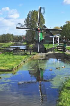 The village - an ethnographic museum in Holland. The picturesque windmill  is reflected in the channel
